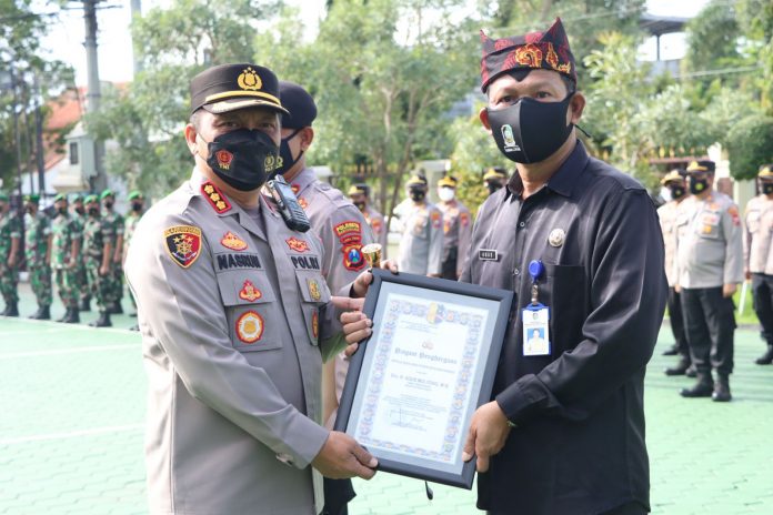 WhatsApp Image 2022-02-24 at 08.26.53 Kapolresta Banyuwangi Kombespol Nasrun Pasaribu menyerahkan penghargaan kepada Camat Pesanggaran, Kamis (24/2/2022) pagi.