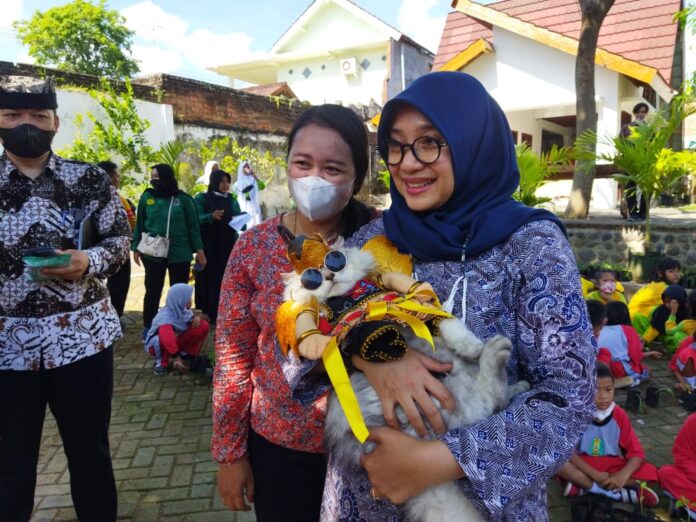 Bupati Banyuwangi Ipuk Fiestiandani menggendong salah satu hewan piaraan dalam fashion show di Banyuwangi, Selasa (13/12/2022) siang.