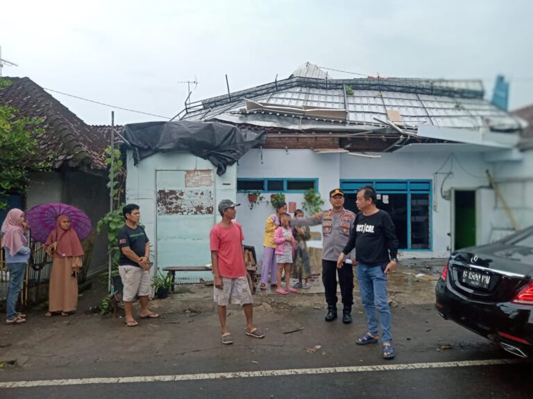 Warga membersihkan atap rumah yang rusak diterjang angin putting beliung, Kamis (29/12/2022) siang.