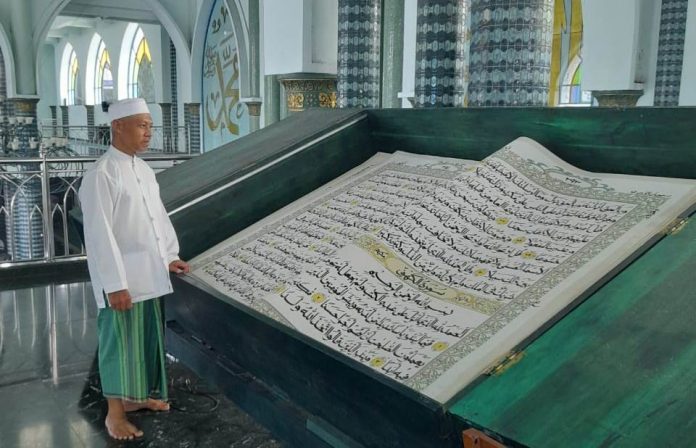 Warga membaca Al-Qu’ran raksasa di Masjid Agung Baiturrahman Banyuwangi selama Ramadan.