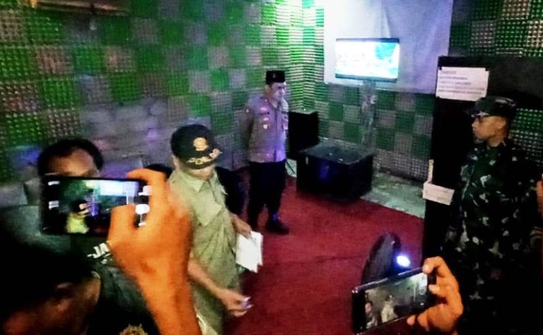 Polisi bersama Satpol PP dan TNI merazia rumah karaoke berkedok radio yang nekat buka di Kecamatan Glagah, Banyuwangi, Jumat (7/4/2023) malam.