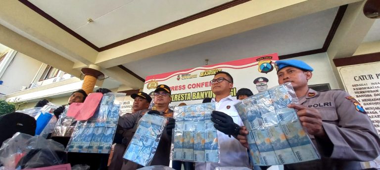 Kapolresta Banyuwangi Kombespol Deddy Foury Millewa menunjukkan barang bukti uang hasil pembobolan ATM, Rabu (7/5/2023). (foto/udi)