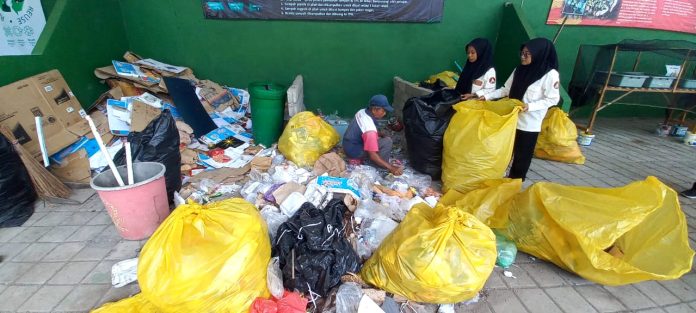 Mahasiswa memilah sampah di pengolahan sampah STIKES Banyuwangi, Selasa (27/6/2023) siang. (foto/udi)