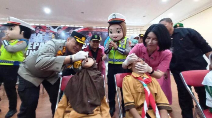 Kapolresta Banyuwangi Kombes Pol. Nanang Haryono bersama Ketua Bhayangkari Cabang Banyuwangi memberikan vaksinasi polio massal ke siswa di Banyuwangi, Sabtu (20/1/2024). (Foto/udi)