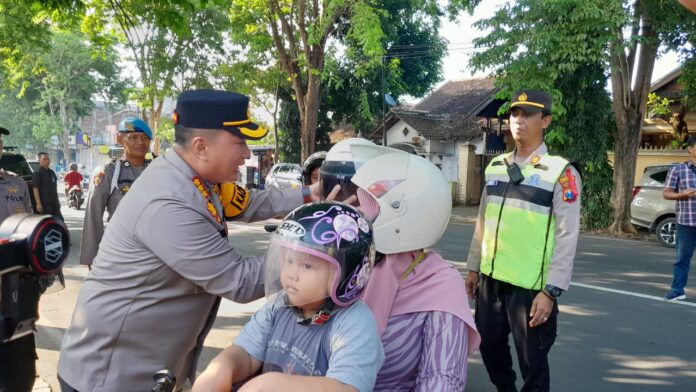 Kapolresta Banyuwangi, Kombes Pol Nanang Haryono membagikan helm kepada siswa SDN 1 Mojopanggung, Kecamatan Giri, Selasa (19/3/2024). (Foto/udi)