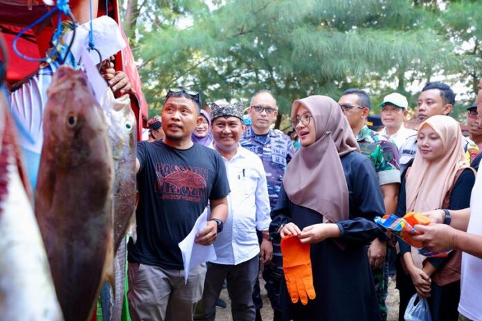 Bupati Banyuwangi Ipuk Fiestiandani melihat ikan hasil tangkapan dalam Festival Memancing di Pantai Bimorejo, Kecamatan Wongsorejo, Minggu (12/5/2024). (Foto/Humas Pemkab Banyuwangi)